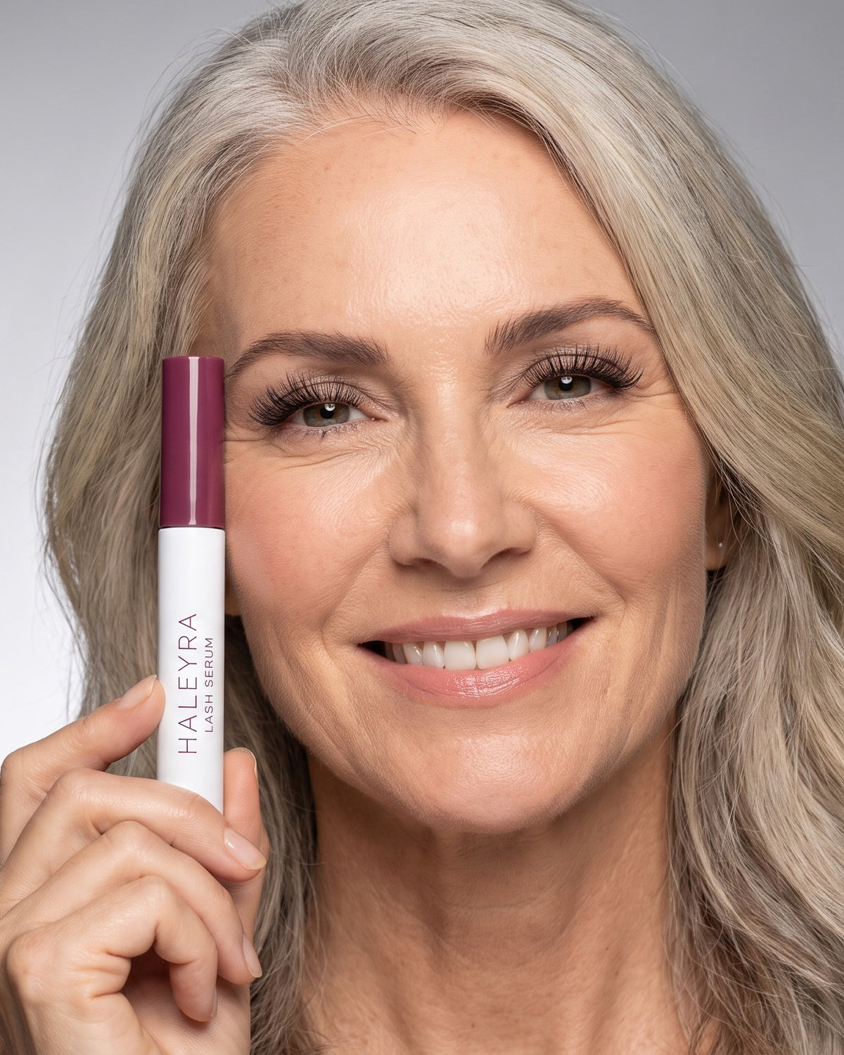 Haleyra — woman in her 50s holding Lash Serum