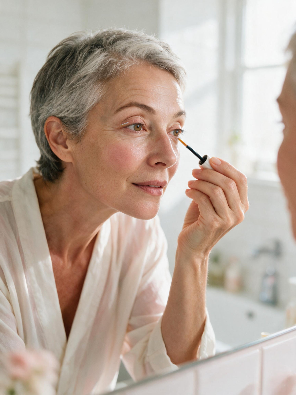 Applying Haleyra lash serum in the mirror